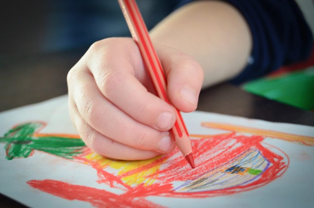 色鉛筆で絵を描く小さな手